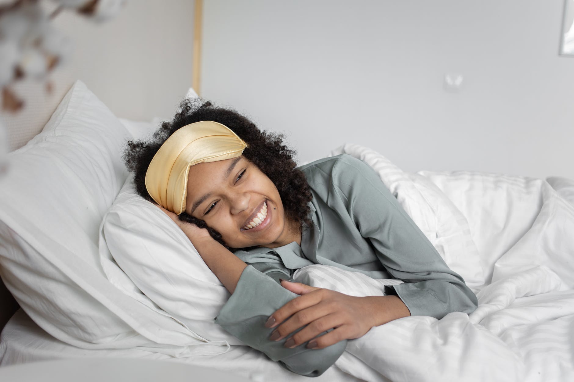 woman in blue long sleeve shirt lying on bed