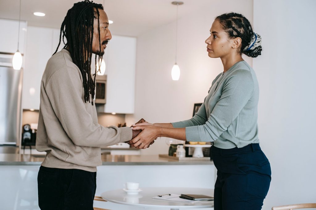 diverse female psychotherapist and male patient shaking hands in studio